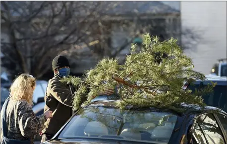  ?? WILL NEWTON — THE ASSOCIATED PRESS ?? Parker Vivier and Marsden Olsen, both of Richmond, Va., prepare to tie their tree to their car after purchasing it from Frank Pichel’s tree lot on Dec. in Richmond.