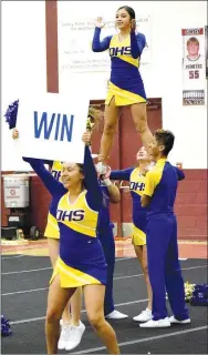  ?? Westside Eagle Observer/MIKE ECKELS ?? Heidi Rubi (front) holds up a win sign and teammate Kaylee Morales gets lifted into the air as the Decatur Cheer team finished its game-day routine during the Gentry Cheer Competitio­n at Pioneer Gym in Gentry Thursday afternoon.