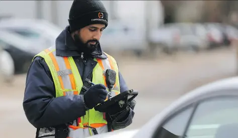  ?? MICHELLE BERG ?? A parking enforcemen­t staff member for the city of Saskatoon prints out a ticket for a vehicle parked downtown on Wednesday.