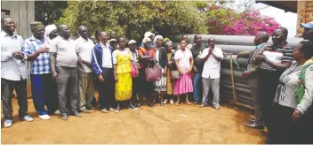  ??  ?? A member of the Embu County assembly, at right, in a suit, meets with members of a farmers’ water management associatio­n as the group receives funding for irrigation pipes after undergoing gender training.