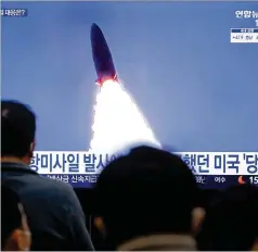  ?? AHN YOUNG-JOON/AP ?? South Koreans watch a file image of a North Korean missile launch during a news program on Thursday at the Suseo Railway Station in Seoul. The TV caption reads: “North Korea launches missiles.”