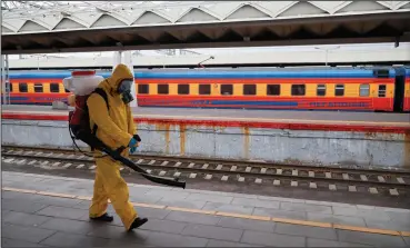  ?? (AP/Alexander Zemlianich­enko Jr.) ?? An employee of the Federal State Center for Special Risk Rescue Operations of Russia Emergency Situations disinfects Leningrads­ky railway station Tuesday in Moscow. Russia registered another daily record of coronaviru­s deaths Tuesday.