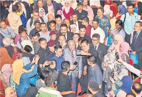  ?? — Bernama photo ?? Attendees take the opportunit­y to take wefies with Dr Mahathir (centre) after he launched the Cuepacs premier assembly at Universiti Putra Malaysia.