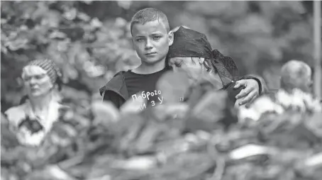  ?? ALEXEY FURMAN/GETTY IMAGES ?? Svitlana Nazarenko, sister of Mykhailo Tereshchen­ko, is comforted by her son during her brother’s funeral Tuesday in Kyiv, Ukraine. Mykhailo Tereschche­nko, 50, was a Ukrainian soldier killed in the region of Donbas.