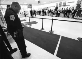  ?? BUTCH COMEGYS/THE TIMES-TRIBUNE VIA AP ?? IN THIS MARCH 14 FILE PHOTO, POLICE PATROLMAN John Burgette, 53, a school resource officer for 18 years, bows his head as Scranton High School students stand in silence to protest gun violence for 17 minutes at the high school in Scranton, Pa.