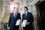  ?? CP PHOTO JUSTIN TANG ?? Minister of Finance Bill Morneau walks Tuesday with Prime Minister Justin Trudeau before tabling the budget in the House of Commons.