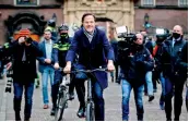  ?? — AFP ?? Dutch resigning Prime Minister Mark Rutte rides a bicycle as he leaves a press conference in The Hague on Friday.