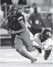  ?? ALICIA DEVINE/FOR THE MIAMI HERALD ?? Champagnat's Kevin Blount tries to outrun a Trinity Christian defender in Thursday’s 41-23 loss at Gene Cox Stadium.