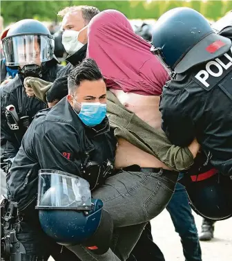  ?? FOTO ČTK/AP ?? Policisté v Berlíně pacifikují muže během sobotní demonstrac­e proti antikorona­virovým opatřením v Německu. Odpůrci opatření pocházejí z řad krajní pravice či se domnívají, že restrikce jsou nástrojem jakéhosi „nového řádu“.