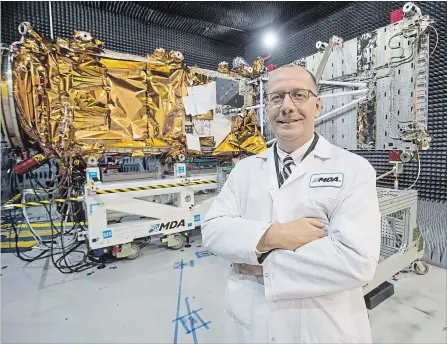  ?? RYAN REMIORZ THE CANADIAN PRESS FILE PHOTO ?? MDA's president Mike Greenley in front of a spacecraft being built at the Canadian Space Agency’s headquarte­rs in Saint-Hubert, Que.