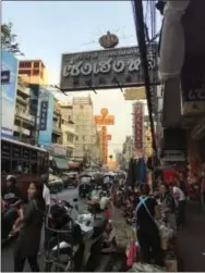  ?? COURTNEY BONNELL — THE ASSOCIATED PRESS ?? In this photo, vendors sell goods on Yaowarat Road, the main thoroughfa­re in Bangkok’s Chinatown, as buses and tuk tuks whiz by. The capital’s Chinatown boasts some of the most famous street food and affordable markets in Thailand.