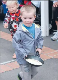  ??  ?? Flipping good: Ben Hoult shows the requisite skill and poise for his Littlies team at the Plimmerton pancake race.