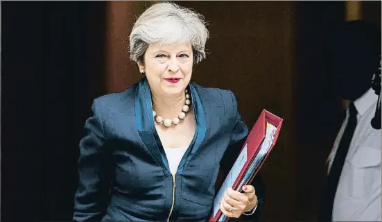  ?? TOLGA AKMEN / AFP ?? La primera ministra britànica, Theresa May, en el moment de sortir ahir de la residència de Downing Street en direcció al Parlament