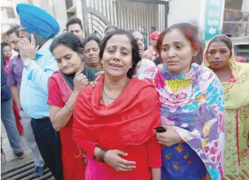 ?? — Reuters ?? Family members cry after seeing the body of their relative after a commuter train ran through a crowd of people on the railway tracks on Friday, outside a hospital in Amritsar, on Saturday.