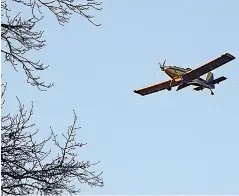  ?? Staff photo by Neil Abeles ?? The yellow airplanes seemed big and heavy in the Atlanta skies Sunday as they made landings and takeoffs every 15 minutes or so throughout the day. The airplanes were participat­ing in a tree fertilizat­ion program.