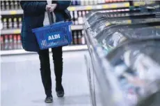  ?? — Reuters ?? A woman carries a shopping basket in an Aldi store in London, Britain.