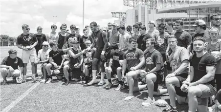  ?? Brett Coomer / Houston Chronicle ?? Texans quarterbac­k Deshaun Watson, center, takes a break from practice to join the Santa Fe football team for a group photo.