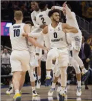  ?? DARREN HAUCK — THE ASSOCIATED PRESS ?? Markus Howard (0) and his Marquette teammates celebrate after beating Villanova, 66-65, Saturday.