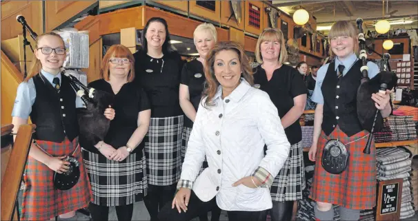  ??  ?? Jane McDonald is pictured with staff from Chalmers of Oban – where she discovered her family tartan – and two members of Oban High School Pipe Band.