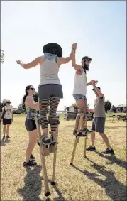  ??  ?? A couple of campers do a dance on stilts.