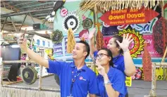  ??  ?? Three Emart Supermarke­t staff take a ‘wefie’ in front of the Gawai festive decoration stage.