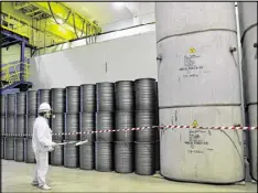  ??  ?? A worker checks the radiation level on barrels in a storage of nuclear waste taken from the fourth unit destroyed by an explosion at the Chernobyl nuclear power plant.