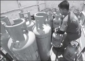  ?? MICHAEL VARCAS ?? A worker loads LPG tanks onto a truck for delivery to outlets in Quezon City yesterday.