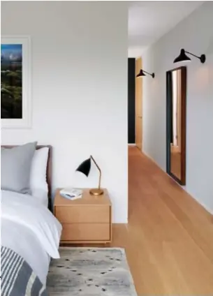  ??  ?? Wall sconces from Design Within Reach light the master bedroom. Bed and nightstand from Urban Mode.