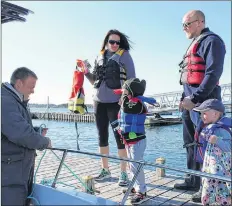  ?? CARLA ALLEN PHOTO ?? Simon LeBlanc of Yarmouth Harbour Tours helps passengers aboard his tour boat. The addition of this new experience and many others in 2018 added to the appeal of the region to locals and tourists.