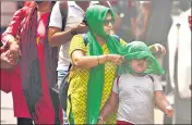  ?? SATISH BATE/HT PHOTO ?? A mother covers the head of her child from the scorching heat at Dadar on Thursday.