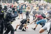  ?? Christophe Gateau AFP/Getty Images ?? GERMAN POLICE use pepper spray during a demonstrat­ion at the G-20 summit in Hamburg.