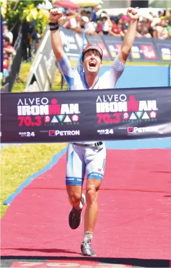  ?? MACKY LIM ?? Markus Rolli of Germany celebrates at the finish line after topping the pro men’s event of the second Alveo Ironman 70.3 Davao at the Azuela Cove yesterday. Name Markus Rolli Age 26 Residence Germany Award Alveo Ironman 70.3 Davao champion FISTS OF VICTORY.