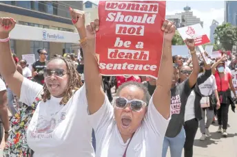  ?? — AFP photos ?? Activists hold up placards as they march through the Central Business District at a demonstrat­ion against an alarming rise in murders of young women in Nairobi.