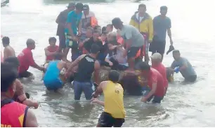  ?? Mercraft 3 AP ?? Volunteers pull a rubber boat with rescued passengers from the ill-fated township, Quezon province, northeaste­rn Philippine­s, on Thursday. — at Infanta