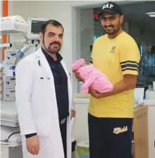  ??  ?? Baby Noora with her father and one of the specialist­s treating her at Zulekha Hospital, Sharjah.