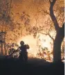  ?? TREVOR HUGHES, USA TODAY ?? Firefighte­r Paige Madrid sprays down an approachin­g wildfire near Kenwood, Calif., on Tuesday.