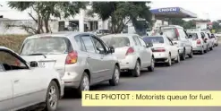 ?? ?? FILE PHOTOT : Motorists queue for fuel.