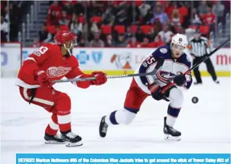  ??  ?? DETROIT: Markus Nutivaara #65 of the Columbus Blue Jackets tries to get around the stick of Trevor Daley #83 of the Detroit Red Wings during the third period at Little Caesars Arena on November 11, in Detroit, Michigan. — AFP