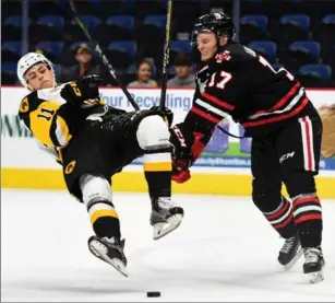  ?? BARRY GRAY, THE HAMILTON SPECTATOR ?? Hamilton’s Isaac Nurse is hammered by Niagara’s William Lochead during first-period action at FirstOntar­io Centre on Saturday night.