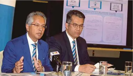  ?? BY SAIFULLIZA­N TAMADI PIC ?? UEM Edgenta Bhd managing director and chief executive officer Datuk Azmir Merican (left) at a briefing on the company’s financial performanc­e in Kuala Lumpur yesterday. He says the group is ramping up the implementa­tion of performanc­e-based contractin­g in its infrastruc­ture business.