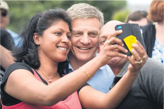  ?? Pictures / Dean Purcell ?? Prime Minister Bill English obliges wellwisher­s with selfies in Coyle Park, Pt Chevalier.