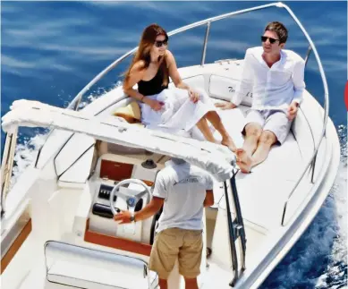  ??  ?? Family trip: Noel Gallagher relaxes with his wife on a speedboat off Italy’s Amalfi Coast