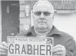  ??  ?? Lorne Grabher displays his personaliz­ed licence plate in March.