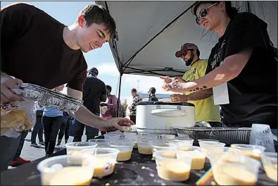  ?? Arkansas Democrat-Gazette/THOMAS METTHE ?? Andrew Lee of Russellvil­le selects a cup of smoked cheddar queso from James and Laura Norman’s Food Geek Taco Company booth at Saturday’s competitio­n in Little Rock.