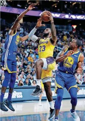  ?? [AP PHOTO] ?? Los Angeles Lakers forward LeBron James (23) shoots between Golden State Warriors forward Kevin Durant, left, and guard Andre Iguodala during an NBA preseason basketball game Wednesday night in Las Vegas.