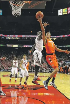  ??  ?? Syracuse’s Michael Carter-Williams avoids the defense of Louisville’s Gorgui Dieng on his way to a first-half layup Saturday. | AP