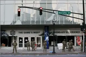  ?? BRYNN ANDERSON — THE ASSOCIATED PRESS ?? The Georgia National Guard lines up in front of the of the College Football Hall of Fame in the aftermath of a demonstrat­ion against police violence on May 30in Atlanta.