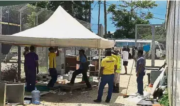  ??  ?? Getting tough: Immigratio­n officials dismantlin­g a shelter at the Australian detention centre on Manus Island in Papua New Guinea. — AFP