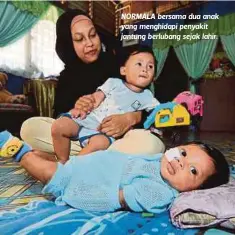  ??  ?? NORMALA bersama dua anak yang menghidapi penyakit jantung berlubang sejak lahir.