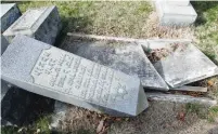  ?? (Reuters) ?? A HEADSTONE, pushed off its base by vandals, lies next to a smashed gravesite yesterday in Philadelph­ia’s Mount Carmel Jewish Cemetery.